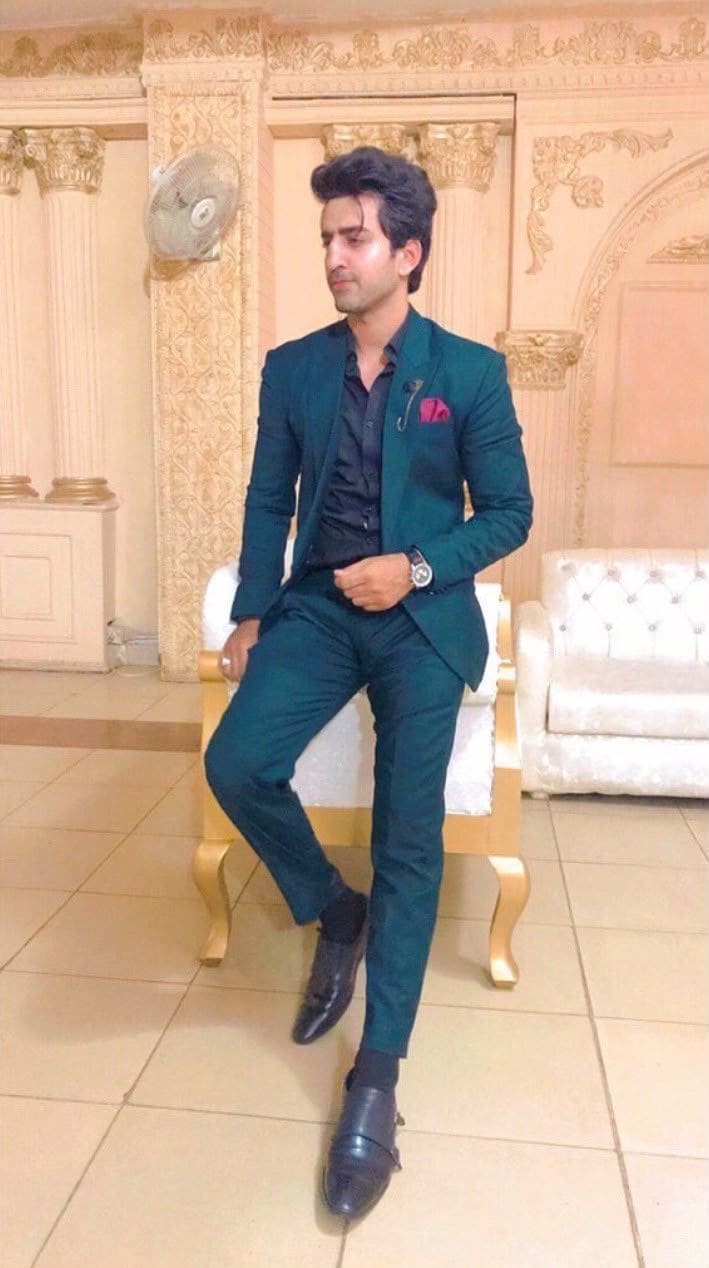 Malik Hamza Javed seated in a teal suit